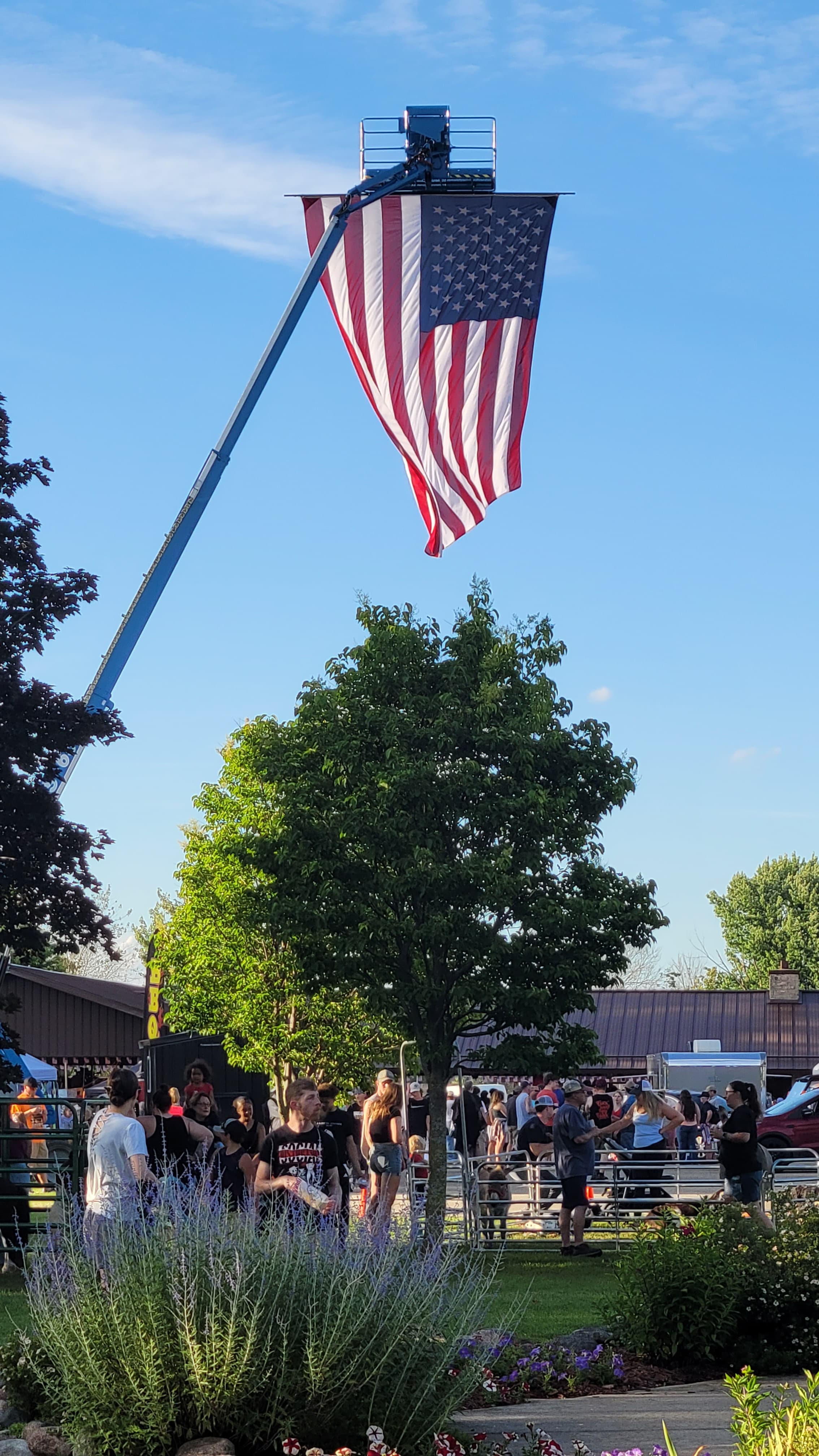 An American flag raised on a TerBeest boom lift at Berlin’s Fourth of July celebration
